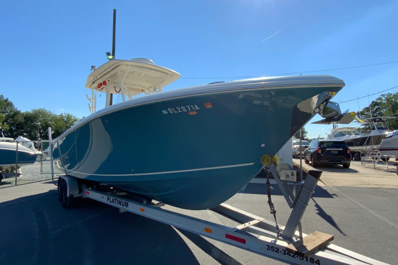 2014 Sailfish 290 CC boat on trailer in sunny outdoor setting.