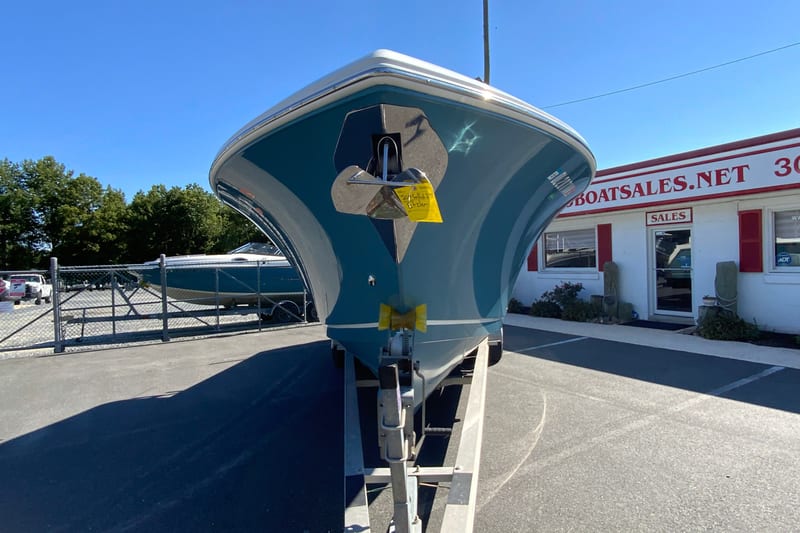 2014 Sailfish 290 CC boat on trailer at dealership, sunny day.