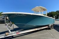 2014 Sailfish 290 CC boat on trailer, parked outdoors under clear blue sky.