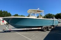 2014 Sailfish 290 CC boat on trailer, parked outdoors under clear blue sky.
