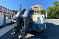2014 Sailfish 290 CC boat with dual Yamaha 300 engines, parked near a sales office.