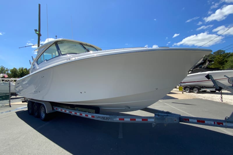 2027 Pursuit D 326 Denali boat on trailer under clear blue sky.