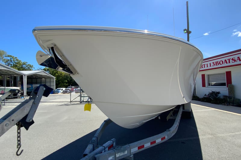 2027 Pursuit D 326 Denali boat on trailer, parked outside dealership.