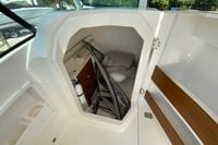 2024 Pursuit DC 246 Dual Console boat interior with compact restroom and storage area.