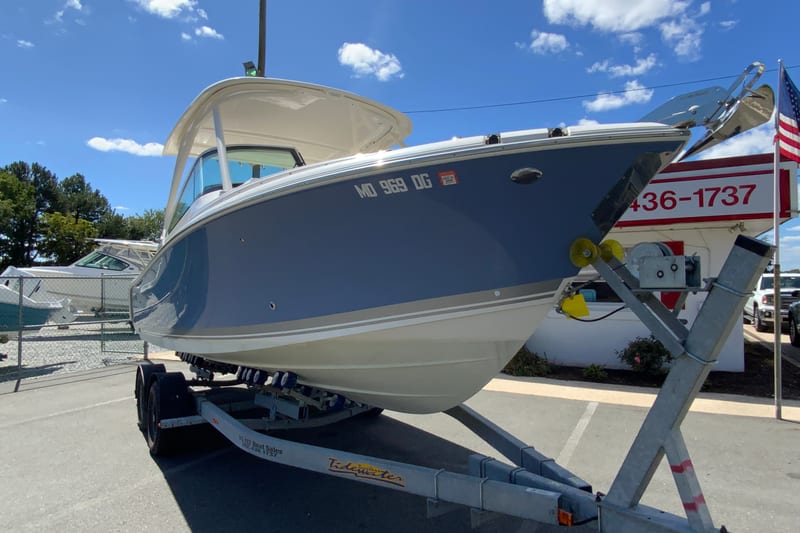 2024 Pursuit DC 246 Dual Console boat on trailer, displayed outdoors under blue sky.