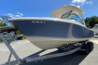 2024 Pursuit DC 246 Dual Console boat on trailer under clear blue sky.