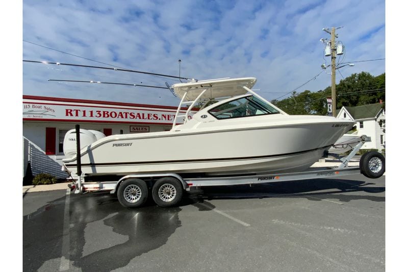 2024 Pursuit DC 266 Dual Console boat on trailer at dealership, clear sky background.