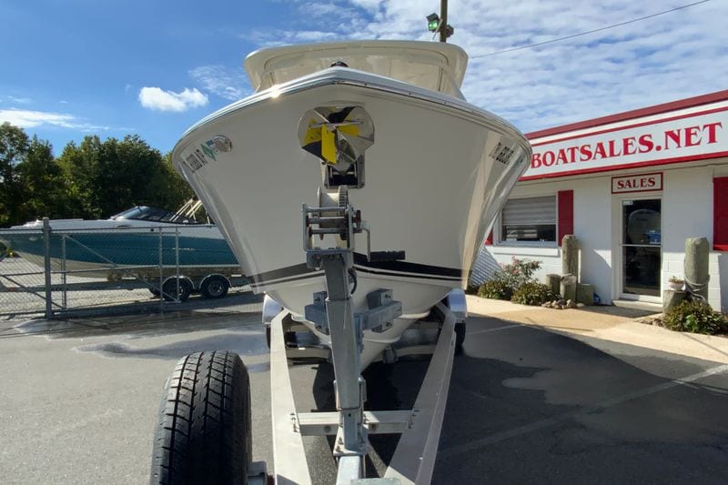 2024 Pursuit DC 266 Dual Console boat on trailer at dealership under blue sky.