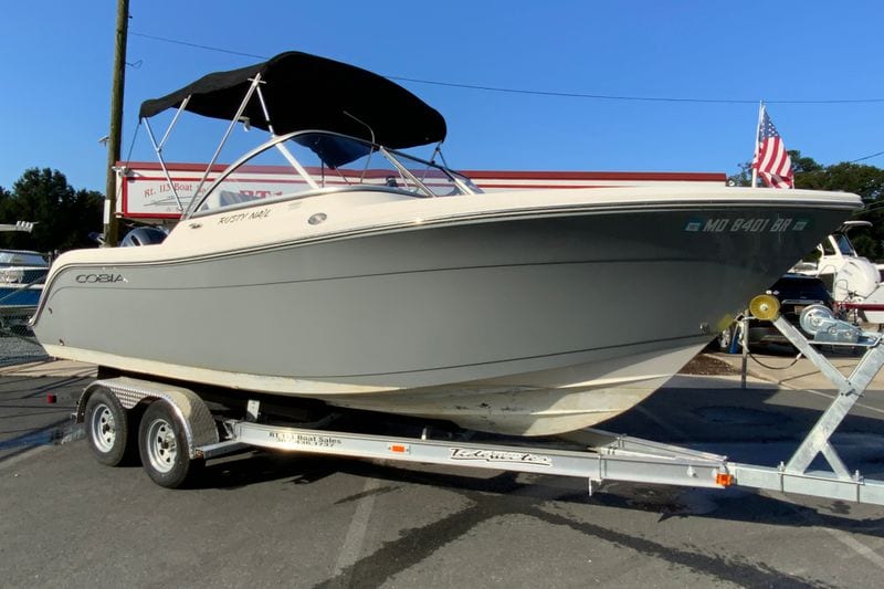 2021 Cobia 220 Dual Console boat on trailer, featuring sleek design and black canopy.