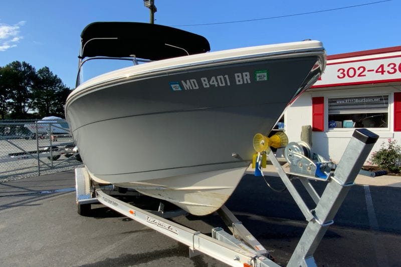 2021 Cobia 220 Dual Console boat on trailer, parked outside dealership.