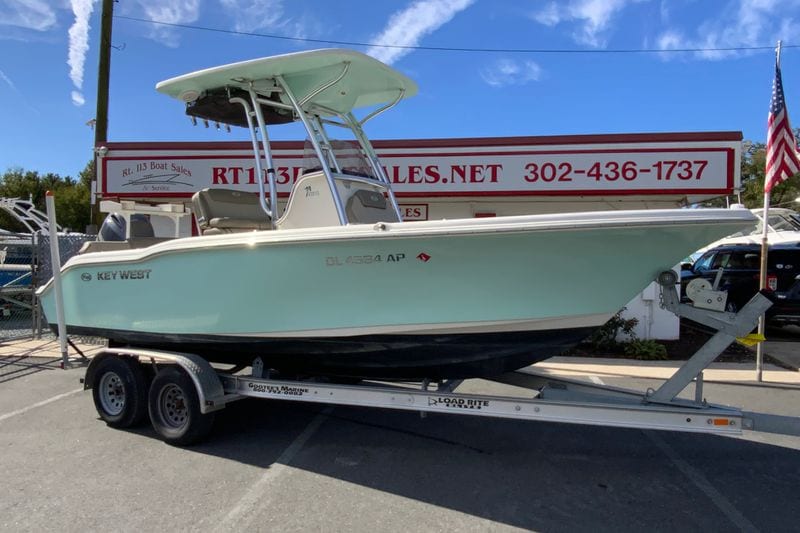 2023 Key West 219 FS boat on trailer at dealership, sunny day.