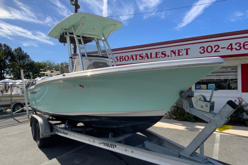 2023 Key West 219 FS boat on trailer at dealership, under clear blue sky.