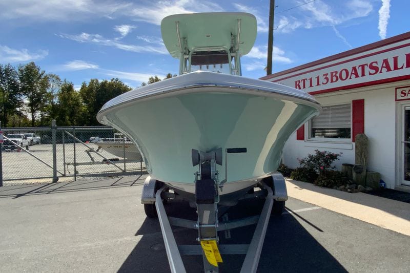 2023 Key West 219 FS boat on trailer at dealership, clear sky background.