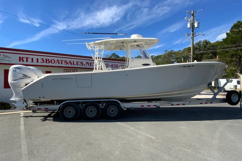 2024 Cobia 320 Center Console boat on trailer at dealership.