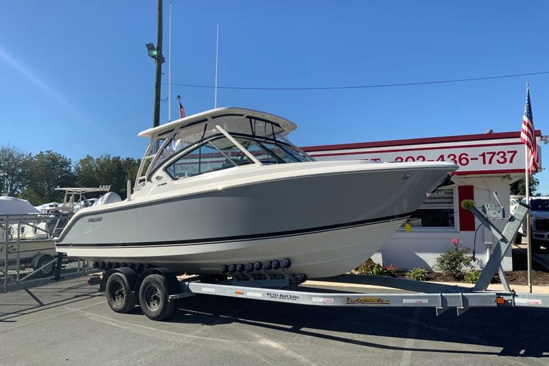 2027 Pursuit D 266 Denali boat on trailer at dealership, sunny day.
