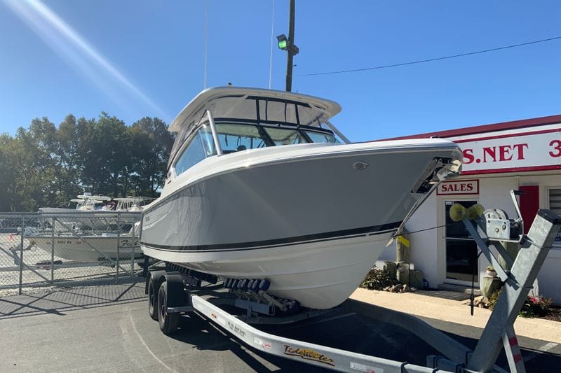2027 Pursuit D 266 Denali boat on trailer at dealership, sunny day.