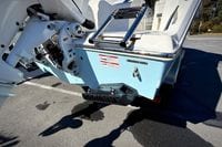 2027 Cobia 250 Dual Console boat rear view with motor and ladder.