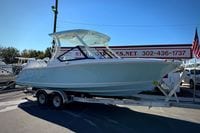 2027 Cobia 250 Dual Console boat on trailer at dealership, sunny day.