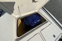 Open storage compartment on 2009 Hewes Redfisher 18 boat with blue bag inside.