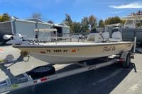 2009 Hewes Redfisher 18 boat on trailer, parked outdoors, with "Fish On" text on side.