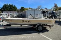 2009 Hewes Redfisher 18 boat on trailer at dealership, side view.