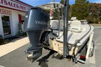2009 Hewes Redfisher 18 boat with Yamaha 150 engine, parked outside sales office.