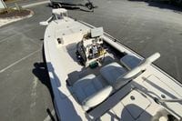 2009 Hewes Redfisher 18 boat with dual seats and steering console, parked on pavement.