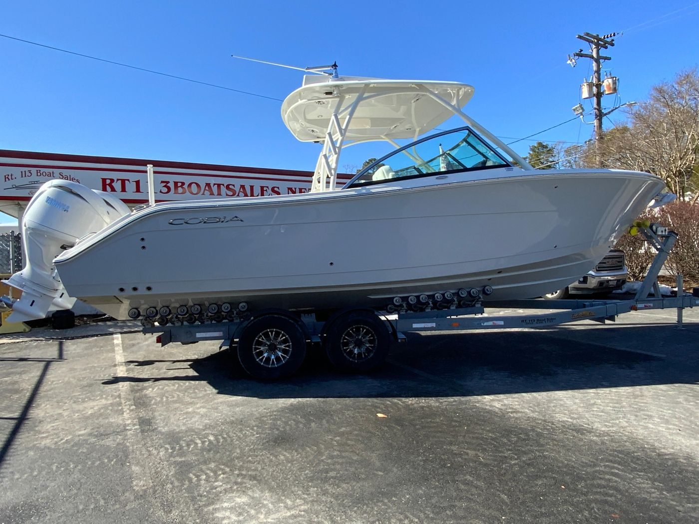 2025 Cobia 280 Dual Console boat on trailer at dealership.