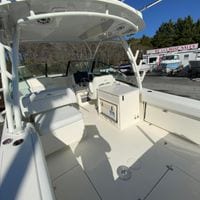 2025 Cobia 280 Dual Console boat interior with seating and helm, at a boat sales lot.
