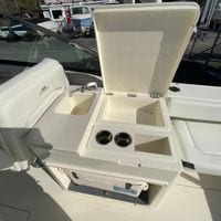 2025 Cobia 280 Dual Console boat with open storage compartment and sink.