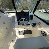 2025 Cobia 280 Dual Console boat cockpit with steering wheel and control panel.