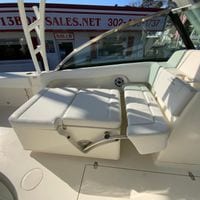 2025 Cobia 280 Dual Console boat interior with white seating and sales office background.