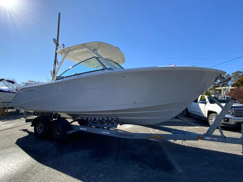 2025 Cobia 280 Dual Console boat on trailer under clear blue sky.