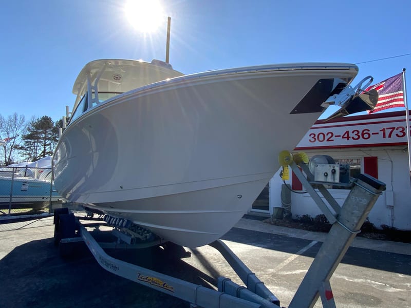2025 Cobia 280 Dual Console boat on trailer under bright sunlight.