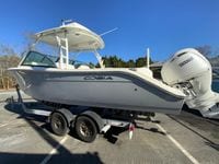 2025 Cobia 280 Dual Console boat on trailer, side view, clear sky background.