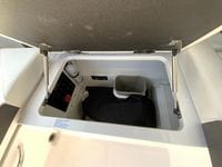 Open storage compartment in 2026 Cobalt R4 OB boat, featuring safety equipment and organized space.
