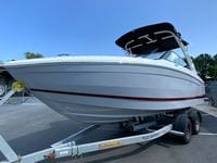 2026 Cobalt R4 OB boat on trailer, sleek design, white hull, black canopy, outdoor setting.