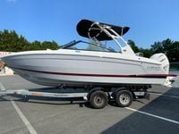 2026 Cobalt R4 OB boat on trailer, white with red stripe, parked outdoors.