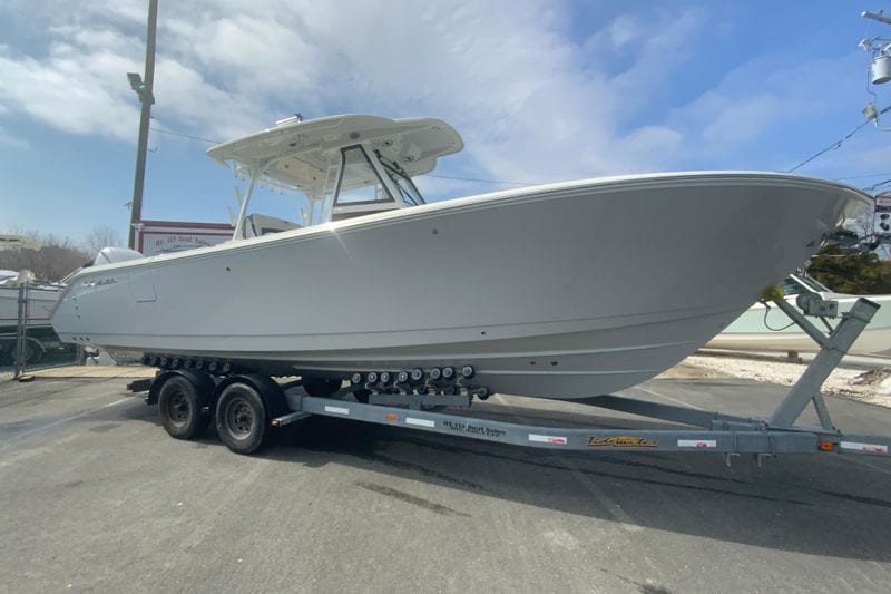 2026 Cobia 305 Center Console boat on trailer under blue sky.