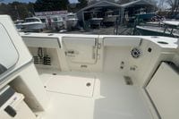 2026 Cobia 305 Center Console boat interior at dealership, showcasing storage and seating features.