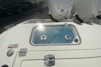 2026 Cobia 305 Center Console boat with dual engines and storage compartment.