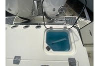 2026 Cobia 305 Center Console boat with open hatch and visible storage compartment.