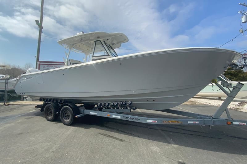 2026 Cobia 305 Center Console boat on trailer under blue sky.