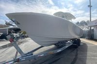 2026 Cobia 305 Center Console boat on trailer under a cloudy sky.