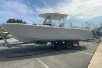2026 Cobia 305 Center Console boat on trailer under clear sky.