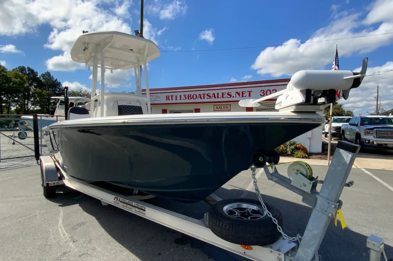 2022 Tidewater 2300 Carolina Bay boat on trailer at dealership, under clear blue sky.