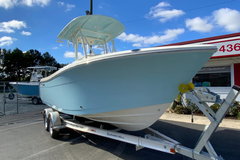 2026 Cobia 220 Center Console boat on trailer, displayed outdoors under blue sky.
