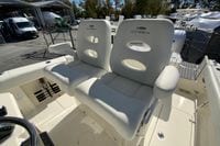 2026 Cobia 265 Center Console boat with plush white seating in a marina setting.