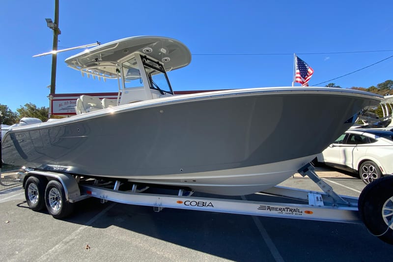 2026 Cobia 265 Center Console boat on trailer, displayed outdoors with American flag.