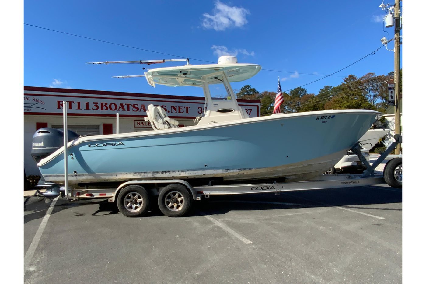2019 Cobia 262 Center Console boat on trailer, parked outside dealership.